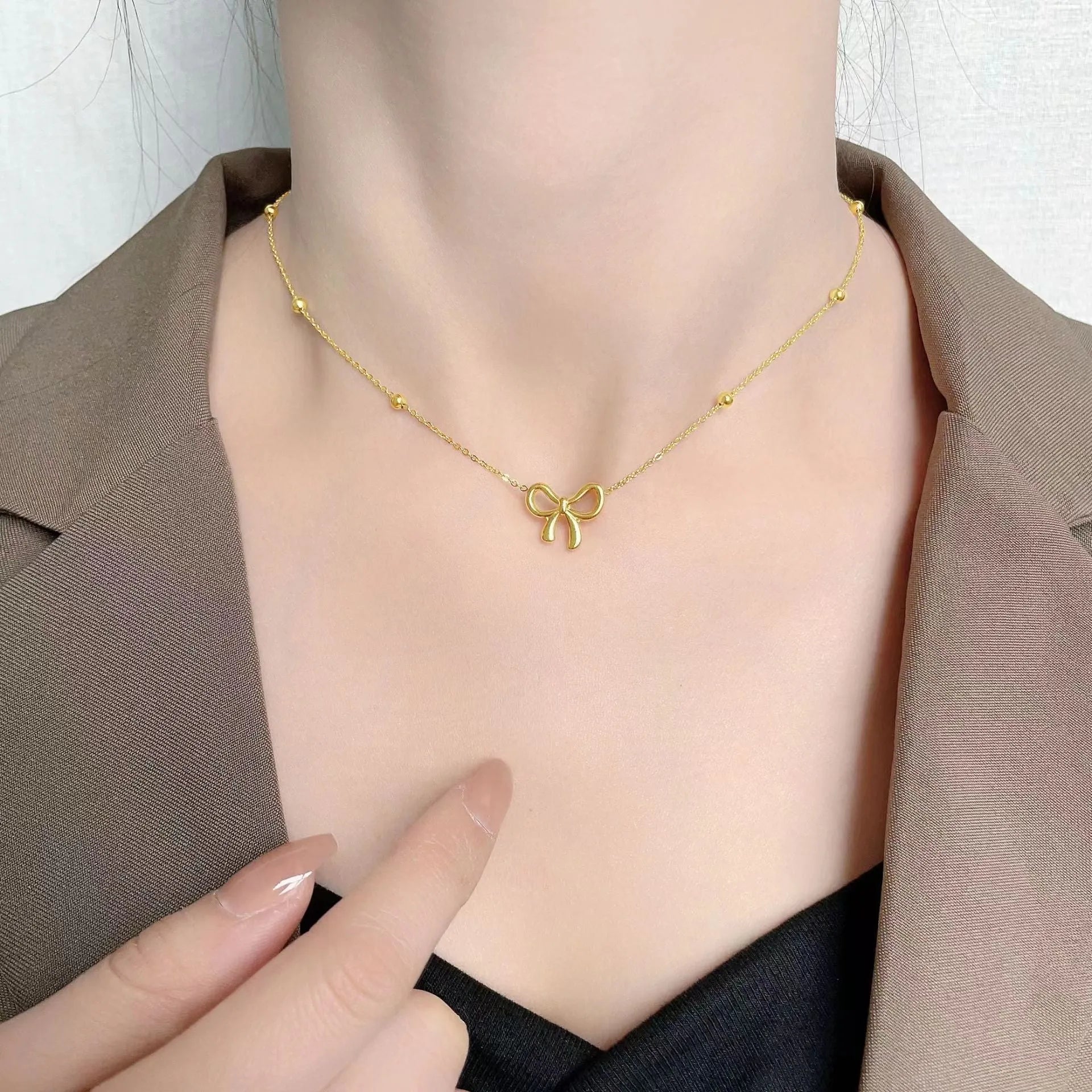 Gold electroplated titanium steel bow necklace with adjustable cross chain