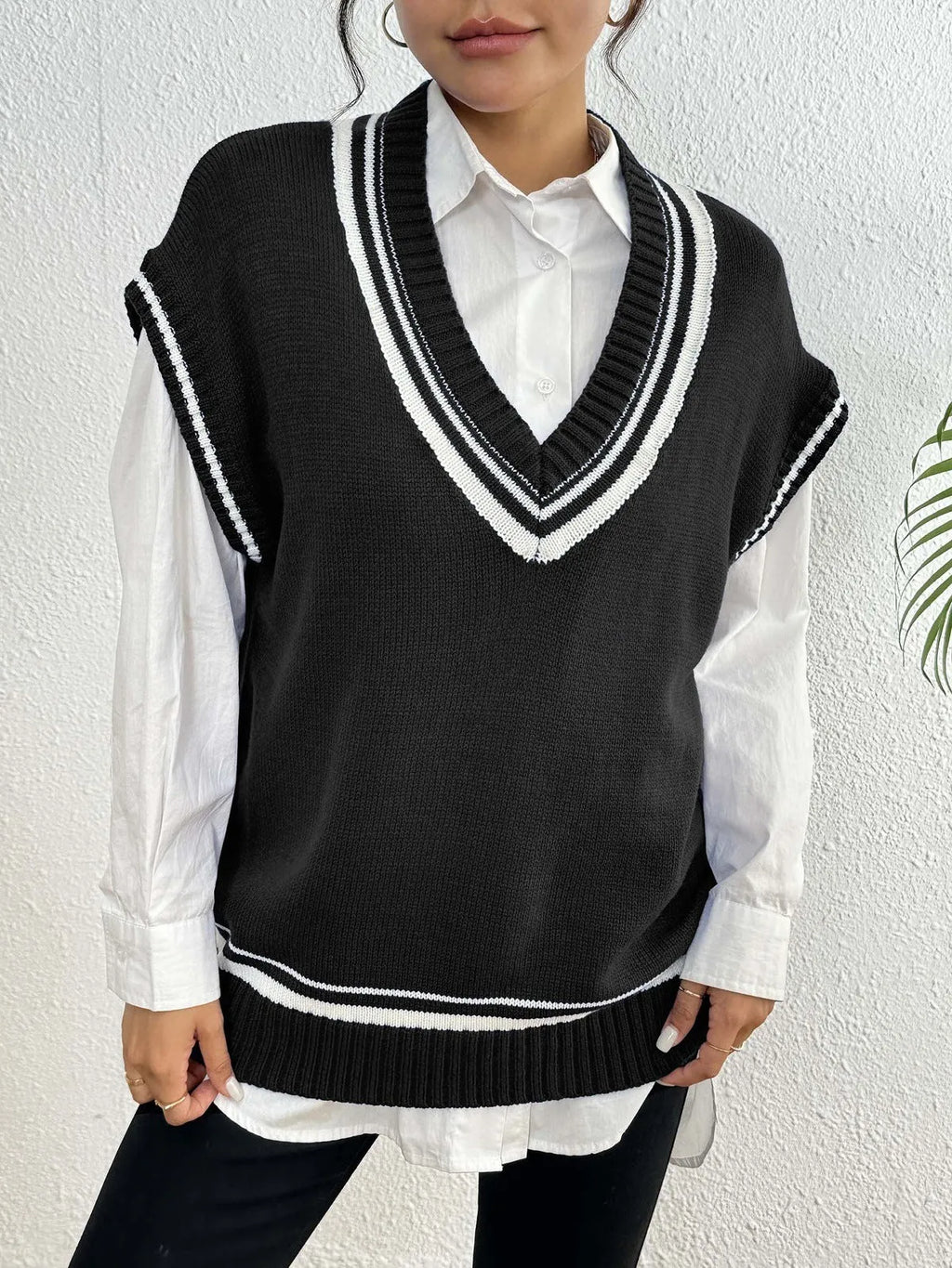 Women's loose fit college style wool vest sweater in blue, laid flat.