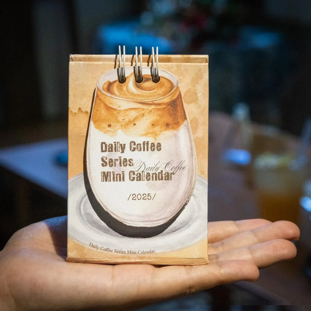Mini coffee-themed desk calendar showing 2025 dates with motivational text
