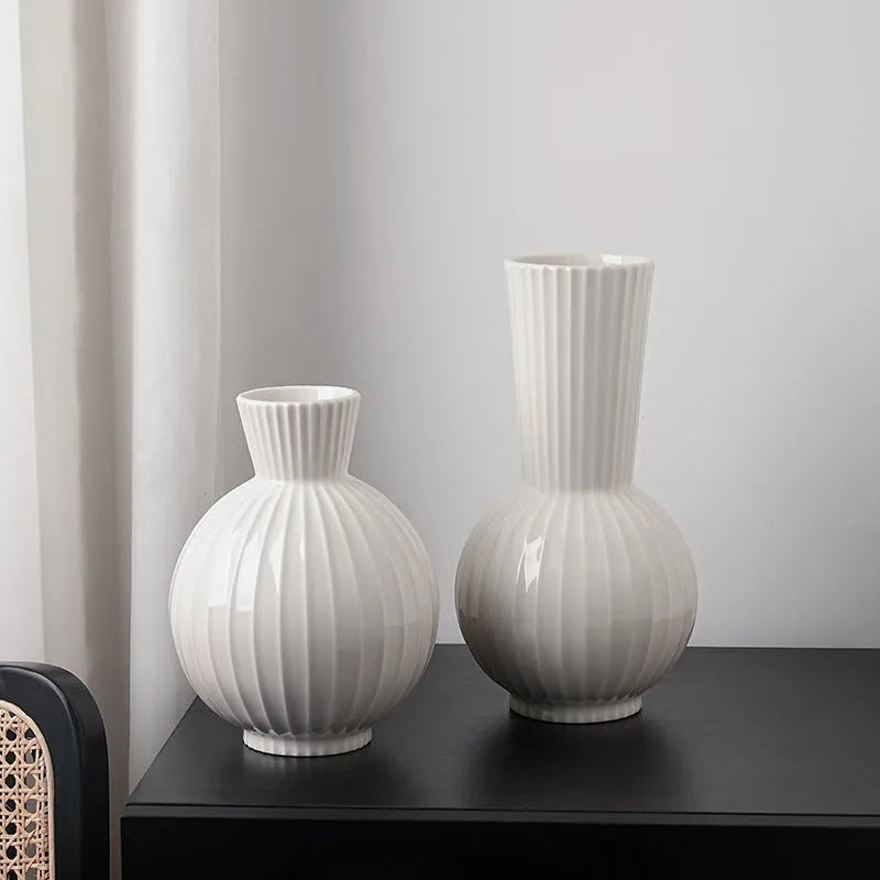 White ceramic ball-shaped vase with striped American country design on a table.