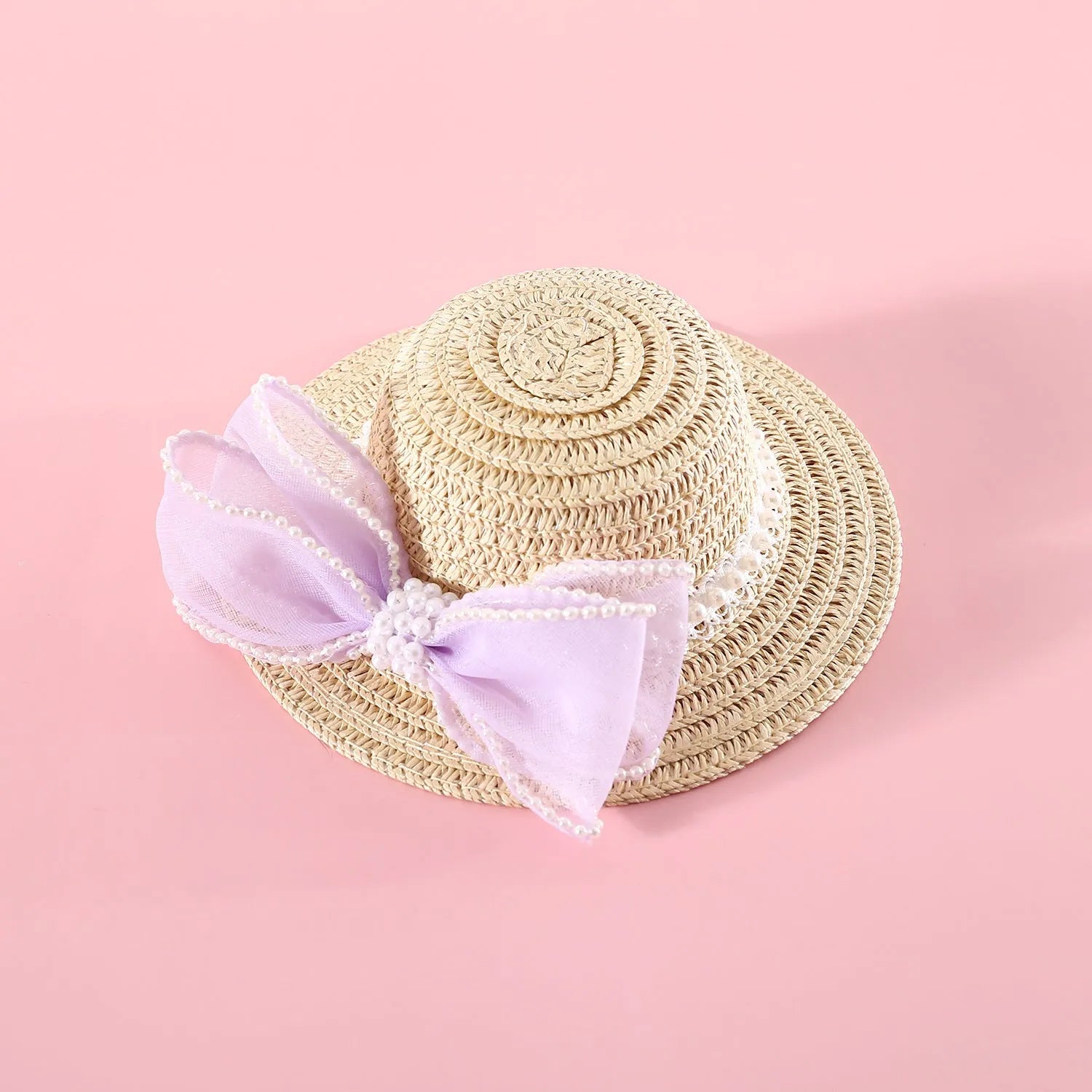 Cat wearing a woven Lafite leaves straw hat with a blue pearl butterfly bow.