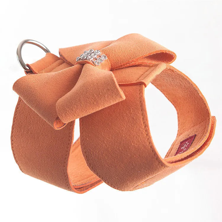 A pink microfiber dog chest strap featuring a sewn-on bowknot shaped like a puppy.