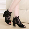 Black gladiator sandals with lace upper, square high heel, and zip closure on ankle