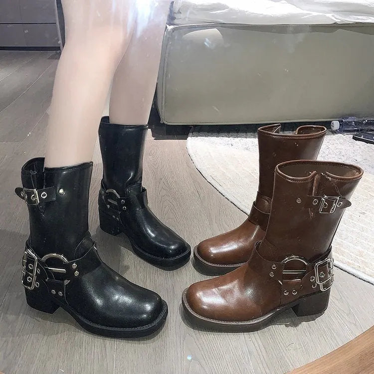 Women's black leather platform boots with belt buckle detail at mid-calf height