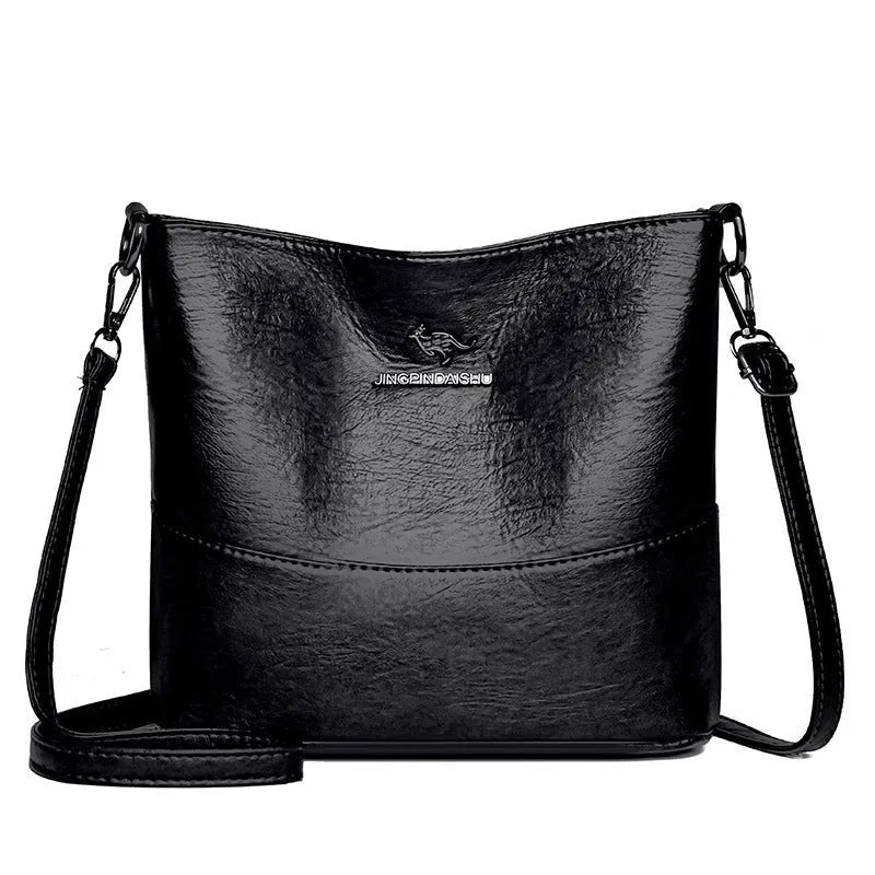 Women's solid colour soft leather bucket shoulder bag with sewing detail on strap, shown in ginger yellow.
