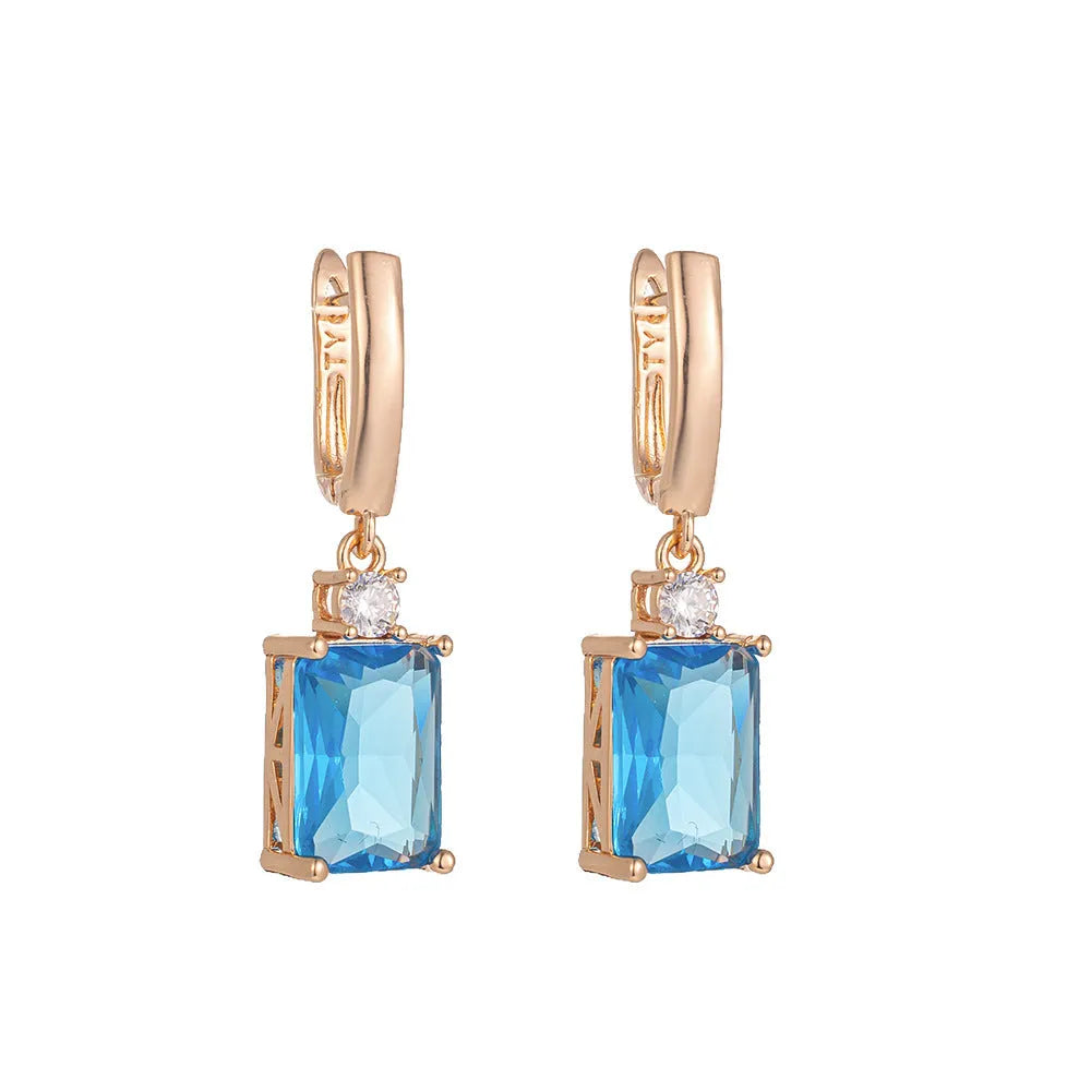 A pair of square geometric earrings with an electroplated gold finish on a copper base.