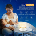 White touch-control baby night light with motion sensor on a nursery bedside table.