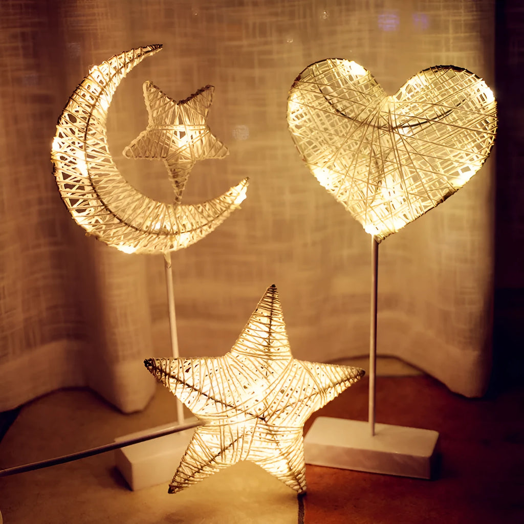 Rattan and copper wire LED table lamp in a star shape on a bedside table.