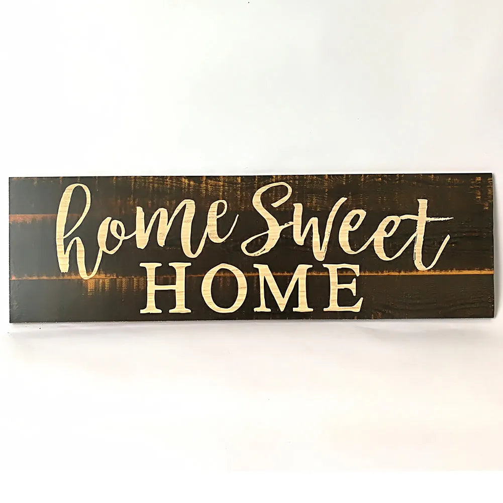 Black wooden wall plaque with carved white HOME SWEET HOME text, showing its rectangular shape.
