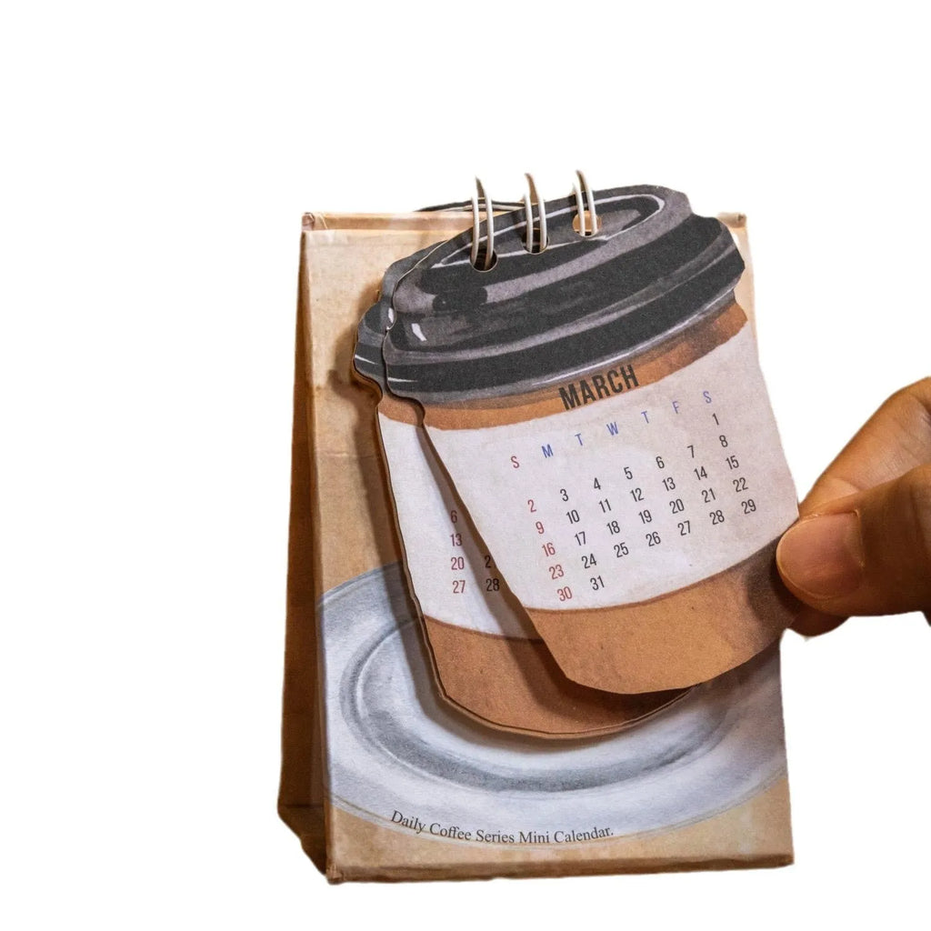 Mini coffee-themed desk calendar showing 2025 dates with motivational text