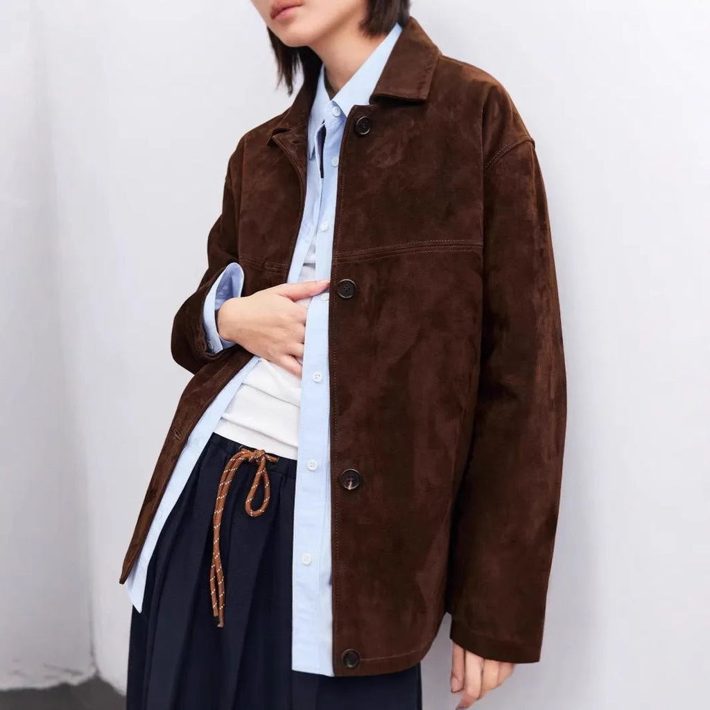 Women's caramel mocha cashmere coat with Peter Pan collar and belt, showing leather stitching and loose retro fit.