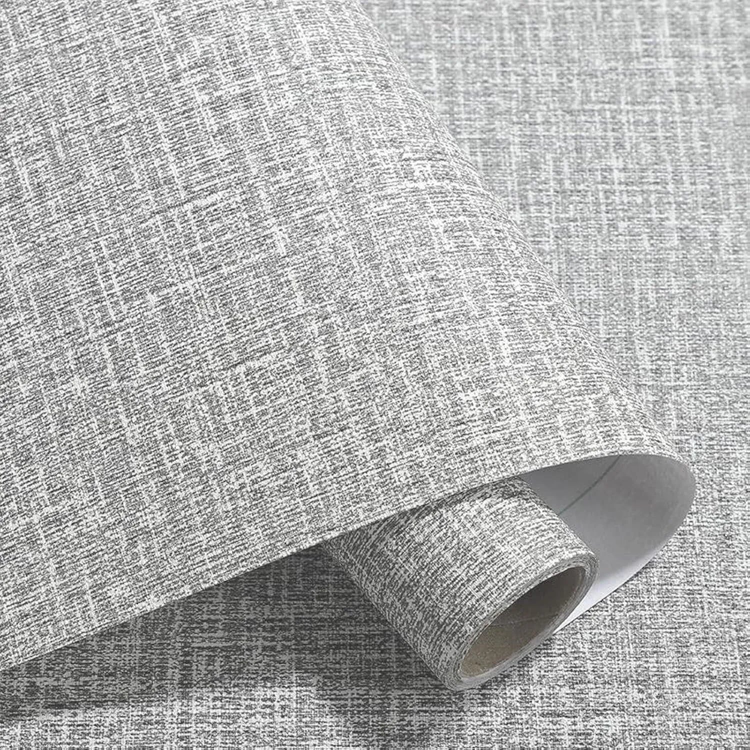 Roll of self-adhesive linen-effect wallpaper in a beige colour for wall renovation.