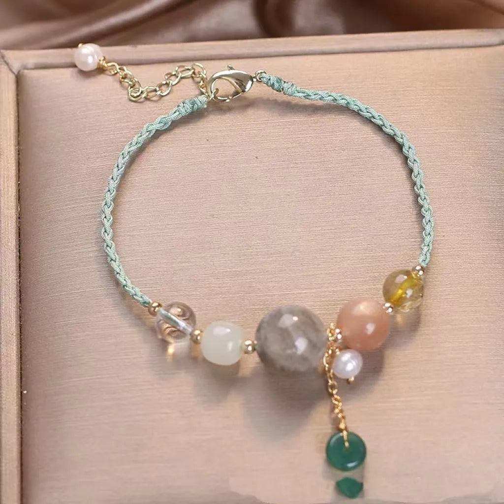 Close-up of a women's adjustable bracelet with crystal and sequin details on a hand-woven peace buckle clasp.
