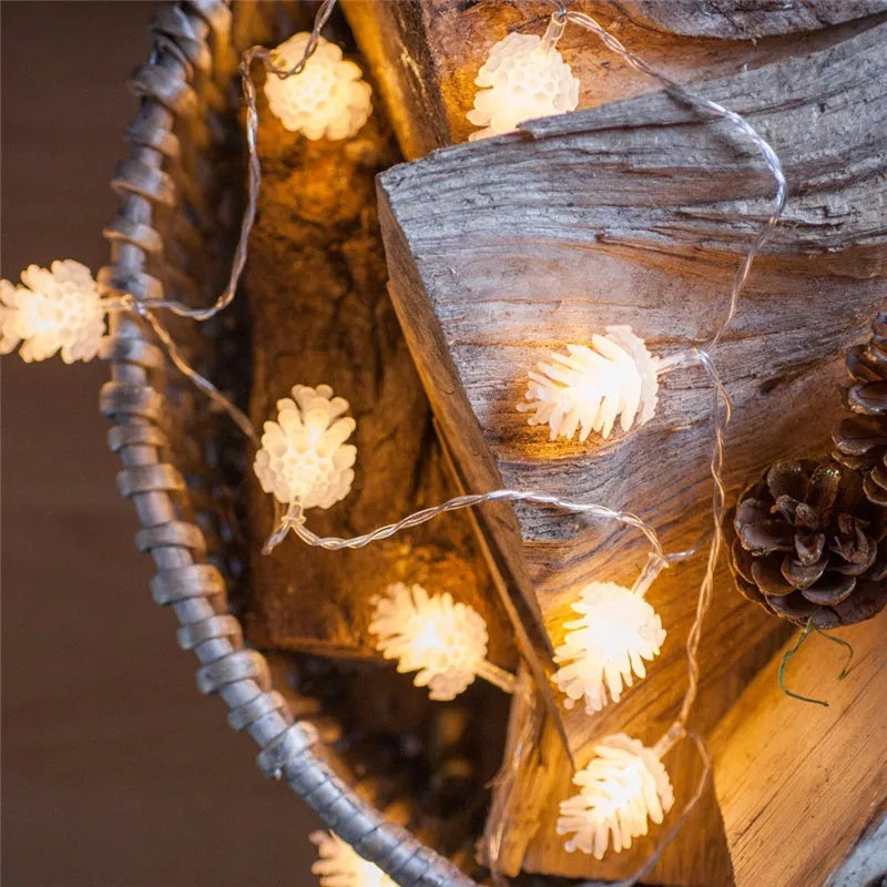 Battery-operated warm white LED string lights with pine cone shaped plastic shells.