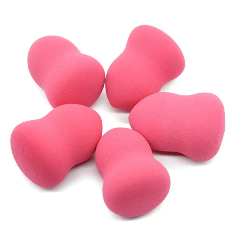 Pink cubic makeup foundation sponge puff on a clean surface.