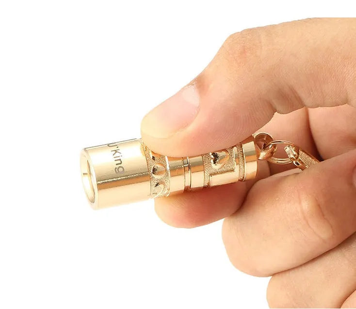 Gold-coloured zinc alloy keychain torch with LED light on a keyring.