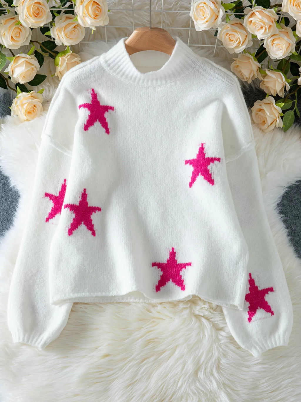 White women's loose turtleneck pullover sweater with a black five-pointed star pattern on the front.