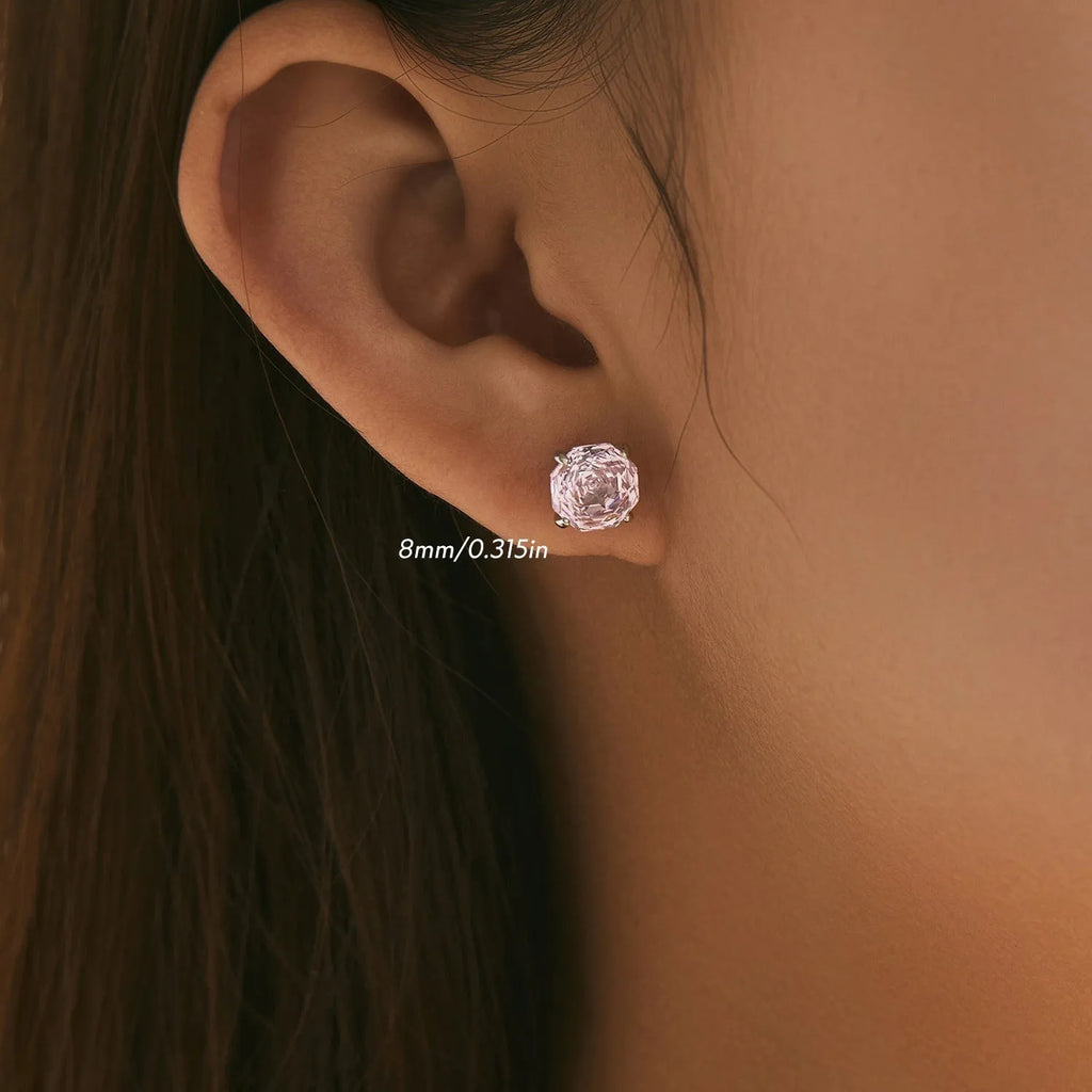 Close-up of a pair of pink rose stud earrings made from S925 sterling silver, shown on a plain background.