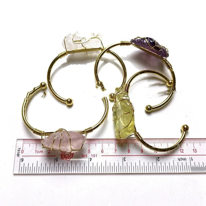 Unisex rough natural crystal bracelet with geometric gold metal winding on a wrist