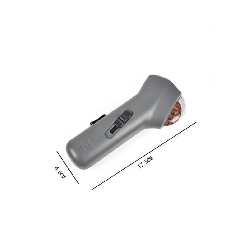 Grey pet snack catapult launcher for dogs and cats, showing compact size and trigger mechanism.