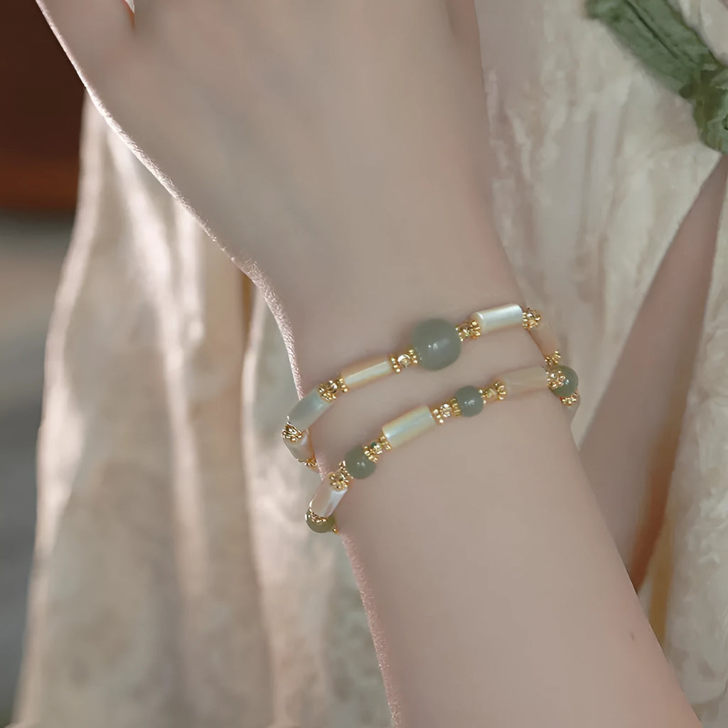 Natural Hetian jade white lip shell bracelet with geometric round beads on woman's wrist