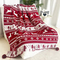 Personalised Christmas blanket with snowflake or reindeer design on a sofa.