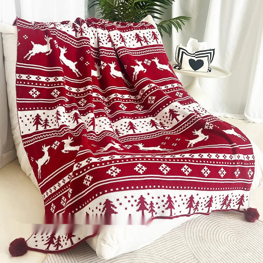 Personalised Christmas blanket with snowflake or reindeer design on a sofa.