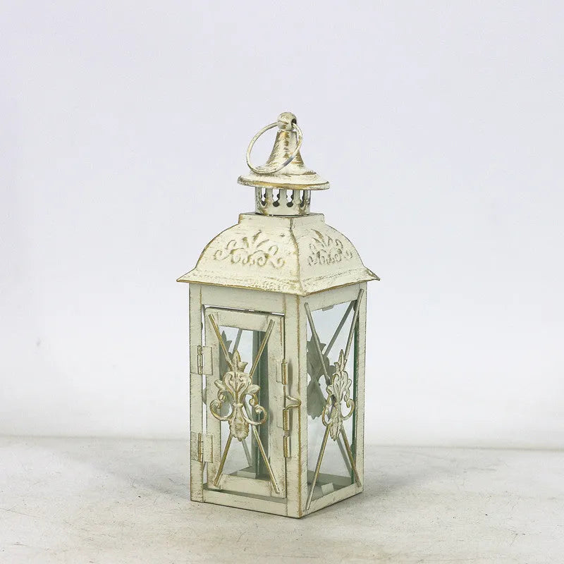 Black wrought iron floor lantern with tempered glass panels, standing on a patio.
