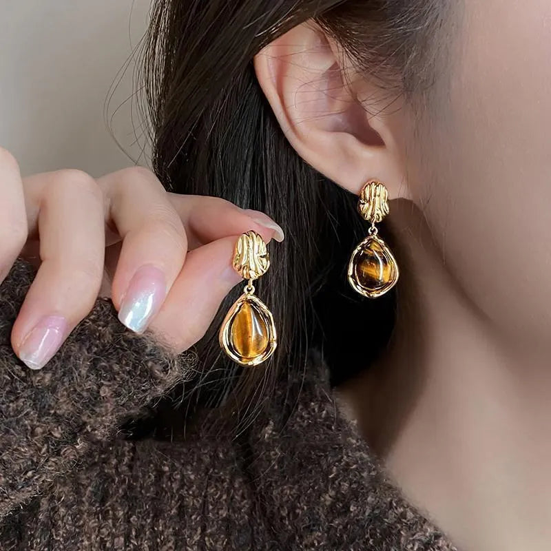 Three pairs of geometric holiday earrings with tassel accents in different styles and colours