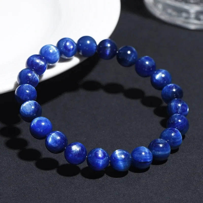 Polished blue crystal ball bracelet with Ruyi charm on a white background.