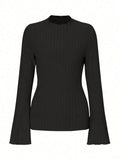 Man wearing a slim-fit long sleeve black top with a subtle brushed stripe texture and round neck.