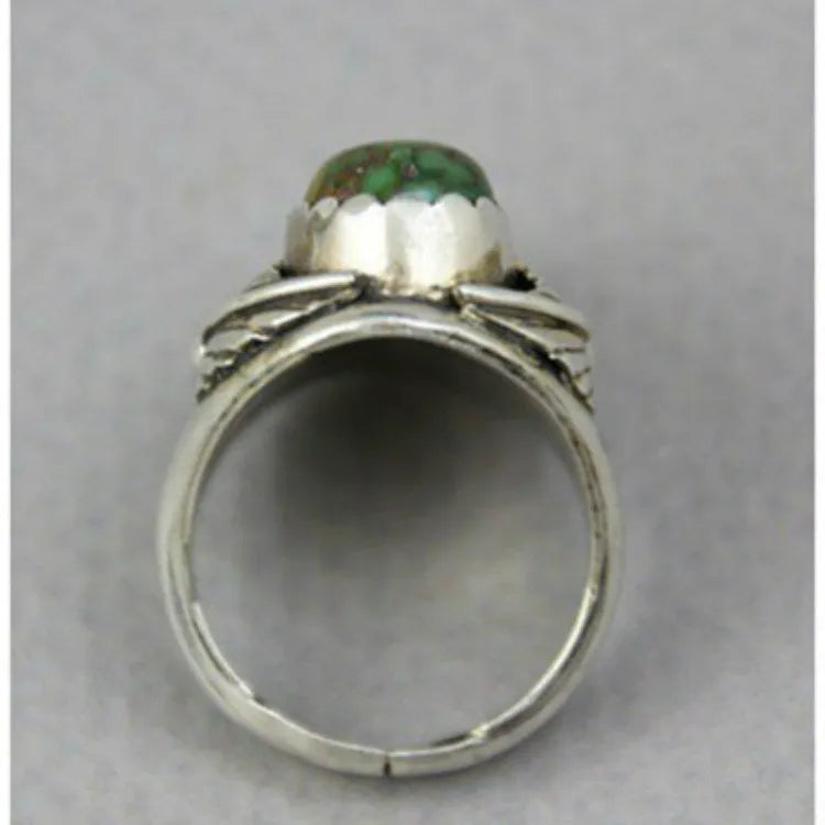 A geometric turquoise ring with a retro inlaid design on a woman's hand.