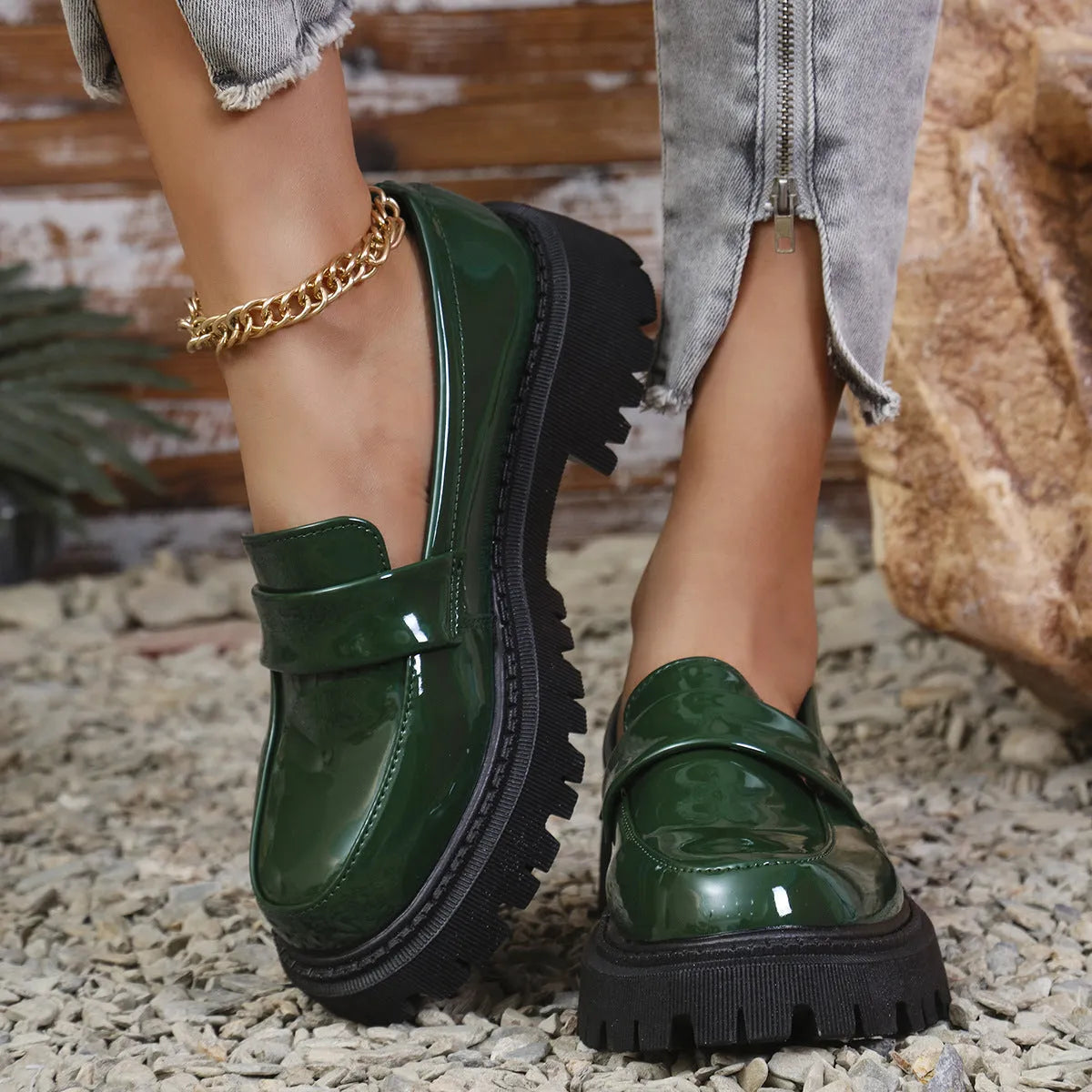 Women's black chunky heel slip-on loafers with a platform sole, shown on a foot.