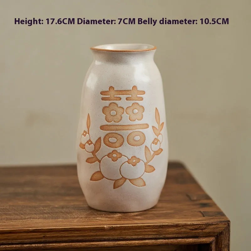 Chinese hand-painted ceramic vase with carved design on wooden desktop
