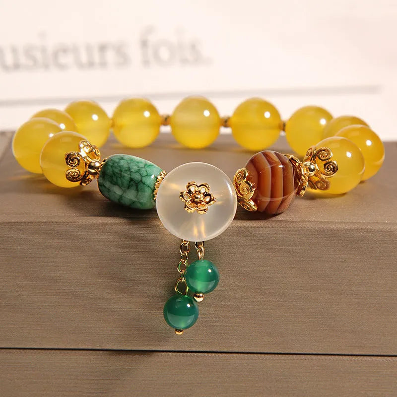 Women's yellow agate crystal beaded bracelet with gold silk thread and tassel.
