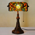 10-inch Tiffany style table lamp with coloured stained glass shade and resin base on a desk.