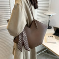 Women's large black PU leather shoulder bag with square shape showing exterior pocket and adjustable handle
