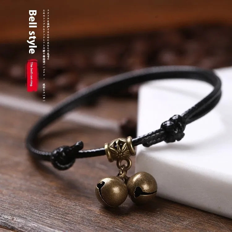 Small dog collar made of nylon rope with a brass bell, shown in black colour.