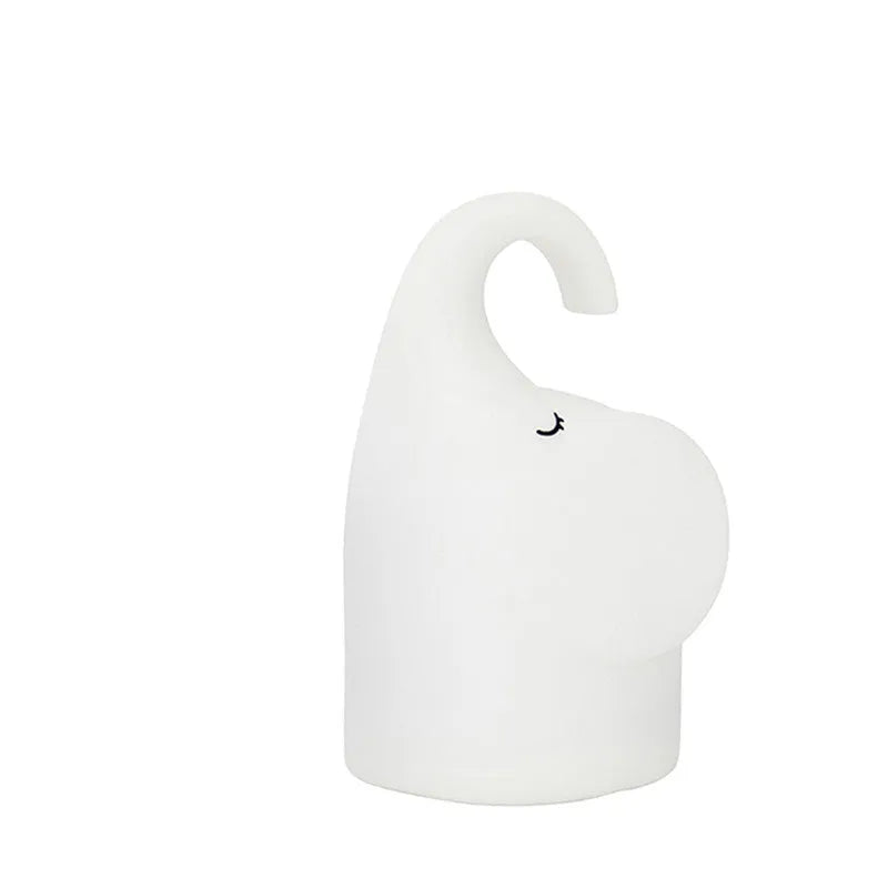 DOMI Elephant-shaped silicone night light in white with warm LED glow on a bedside table.