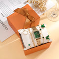 Gold green square women's watch with four matching bracelets on display