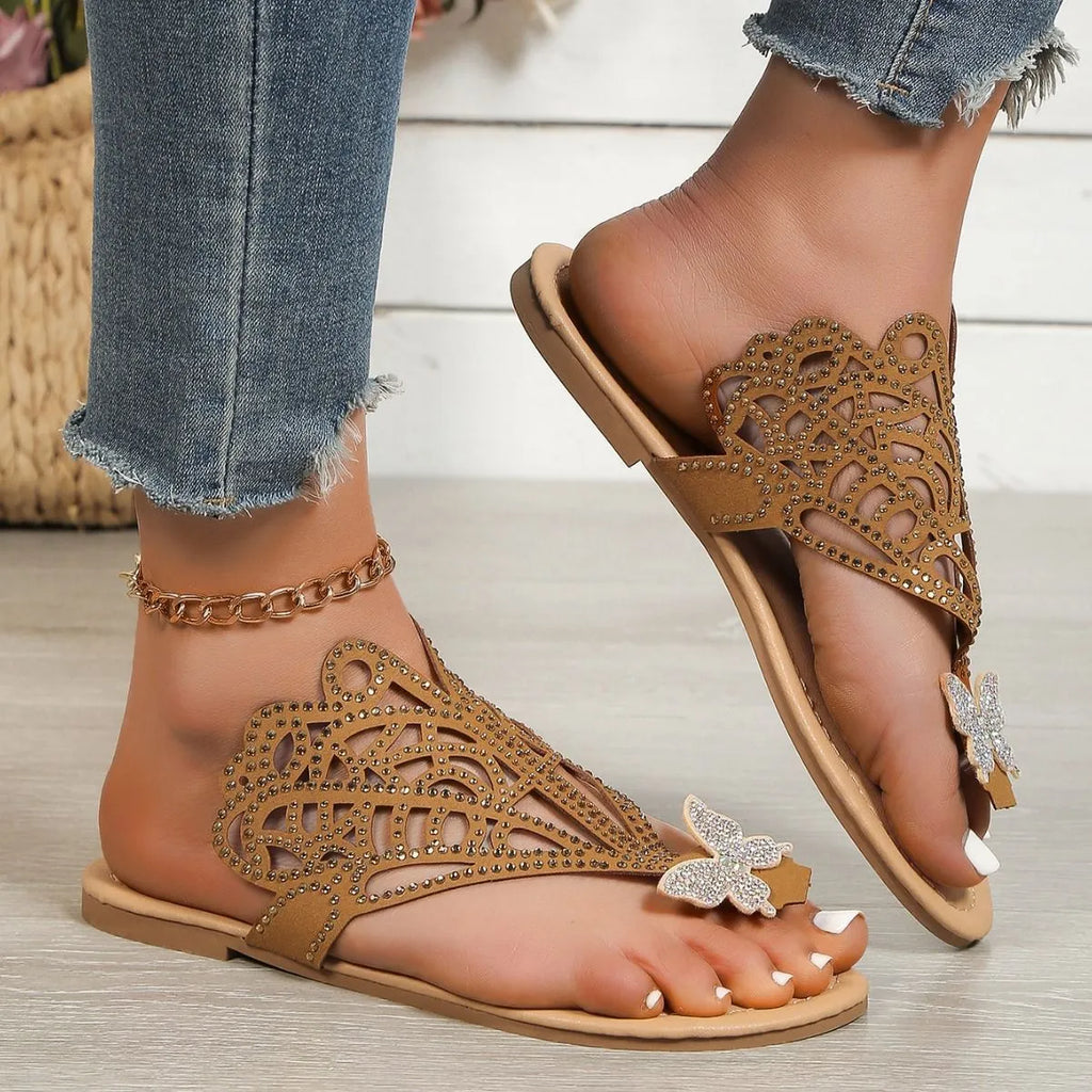 Women's black slip-on sandals with rhinestone detail on flip-toe hollow design and flat rubber sole
