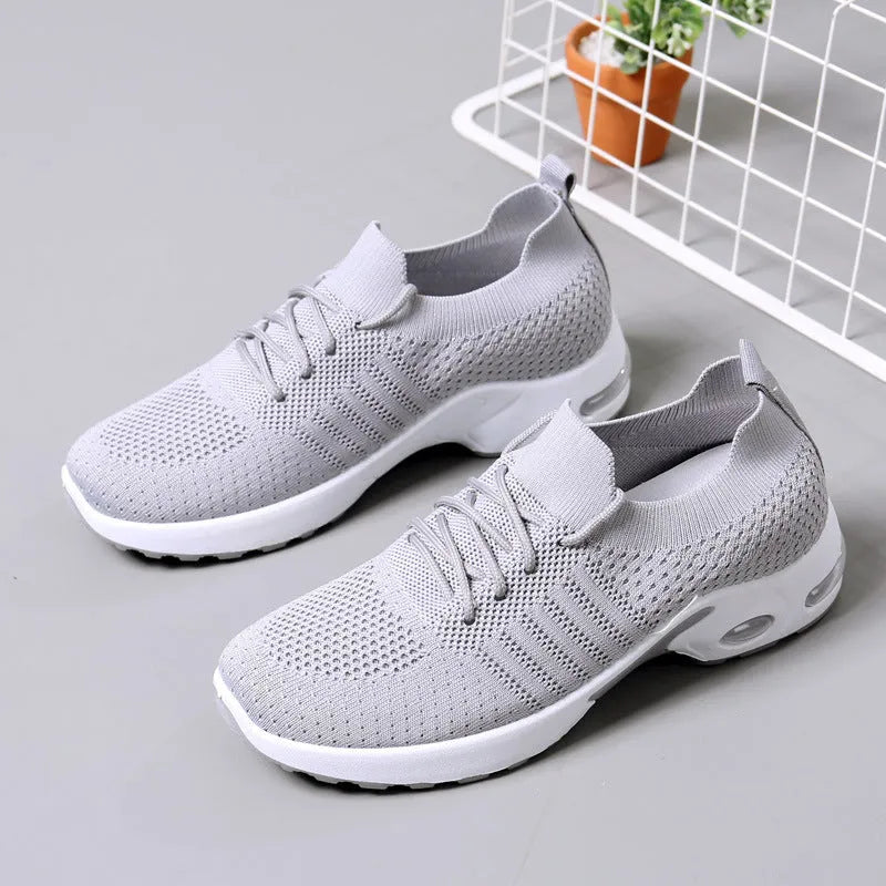 Women's black mesh sneakers with a round toe, front lace-up, and soft PVC sole.