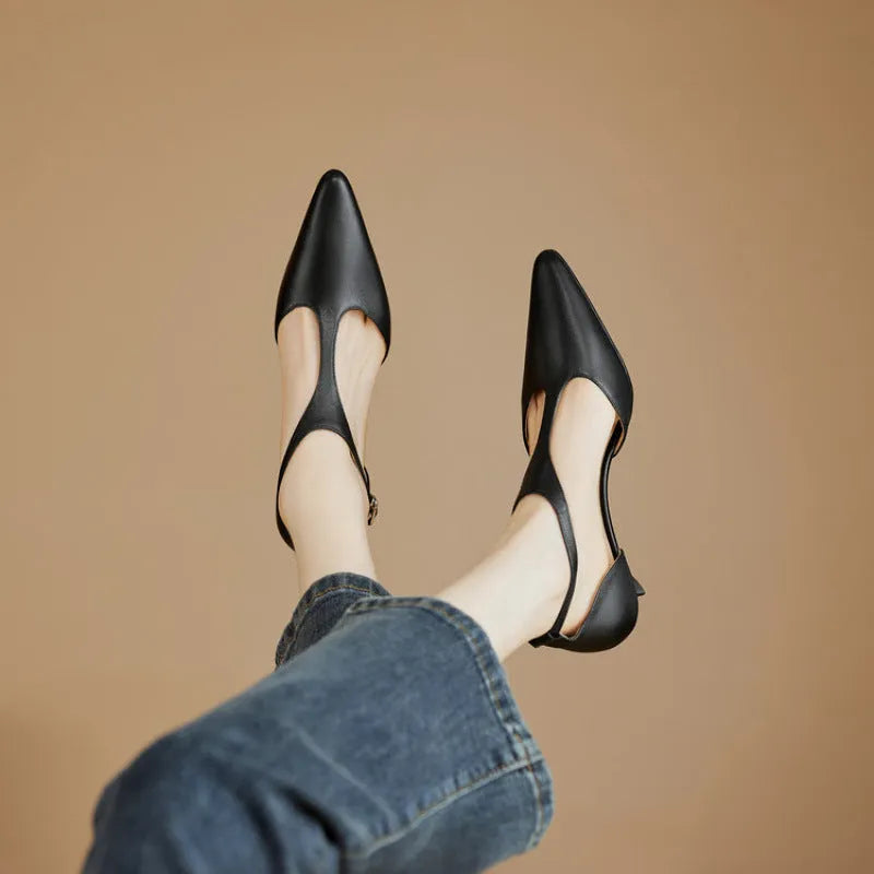 Women's brown and black cowhide high heels with a pointed toe on a white background.