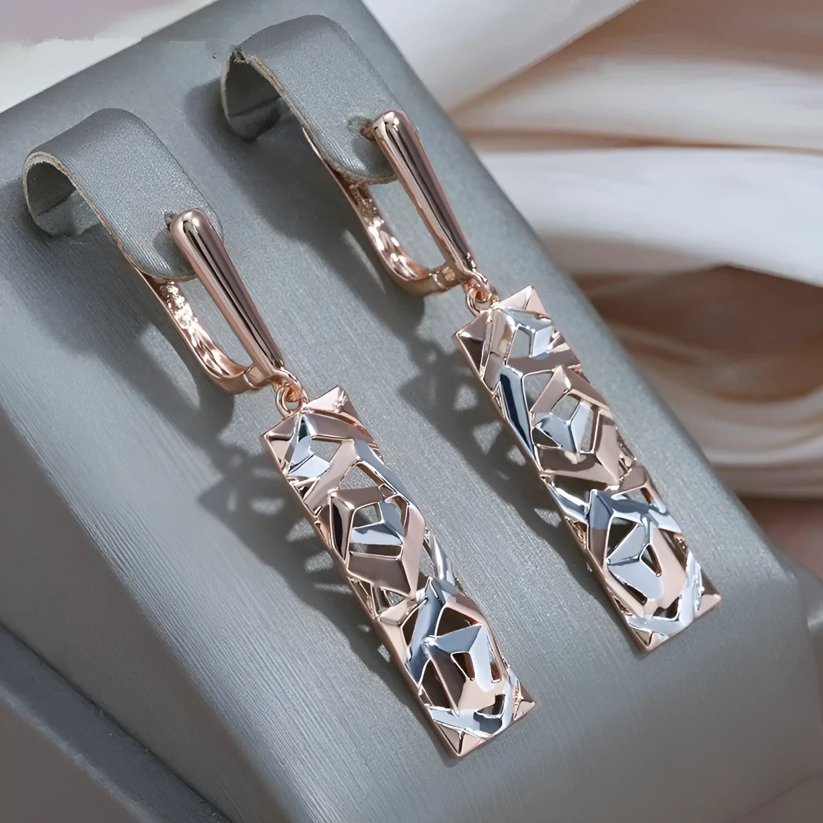 A pair of rectangular hollow stud earrings with a two-tone electroplated finish on a white background.