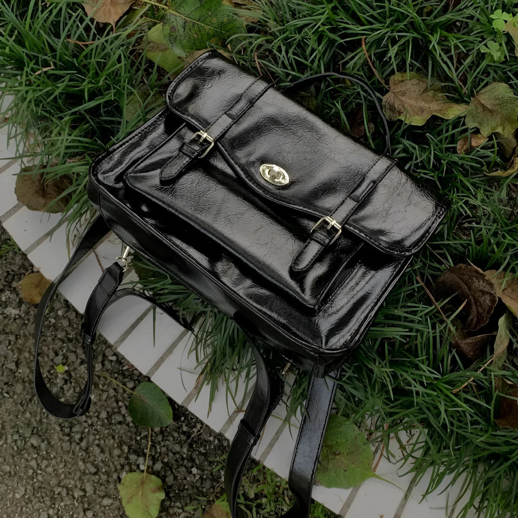 Black college-style messenger bag with oil wax finish and single shoulder strap.