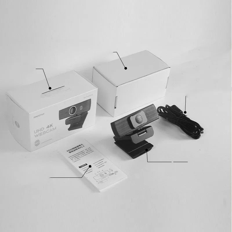 Black USB computer webcam with attached cable and magnetic privacy cover on a desk