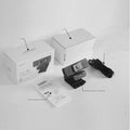 Black USB computer webcam with attached cable and magnetic privacy cover on a desk
