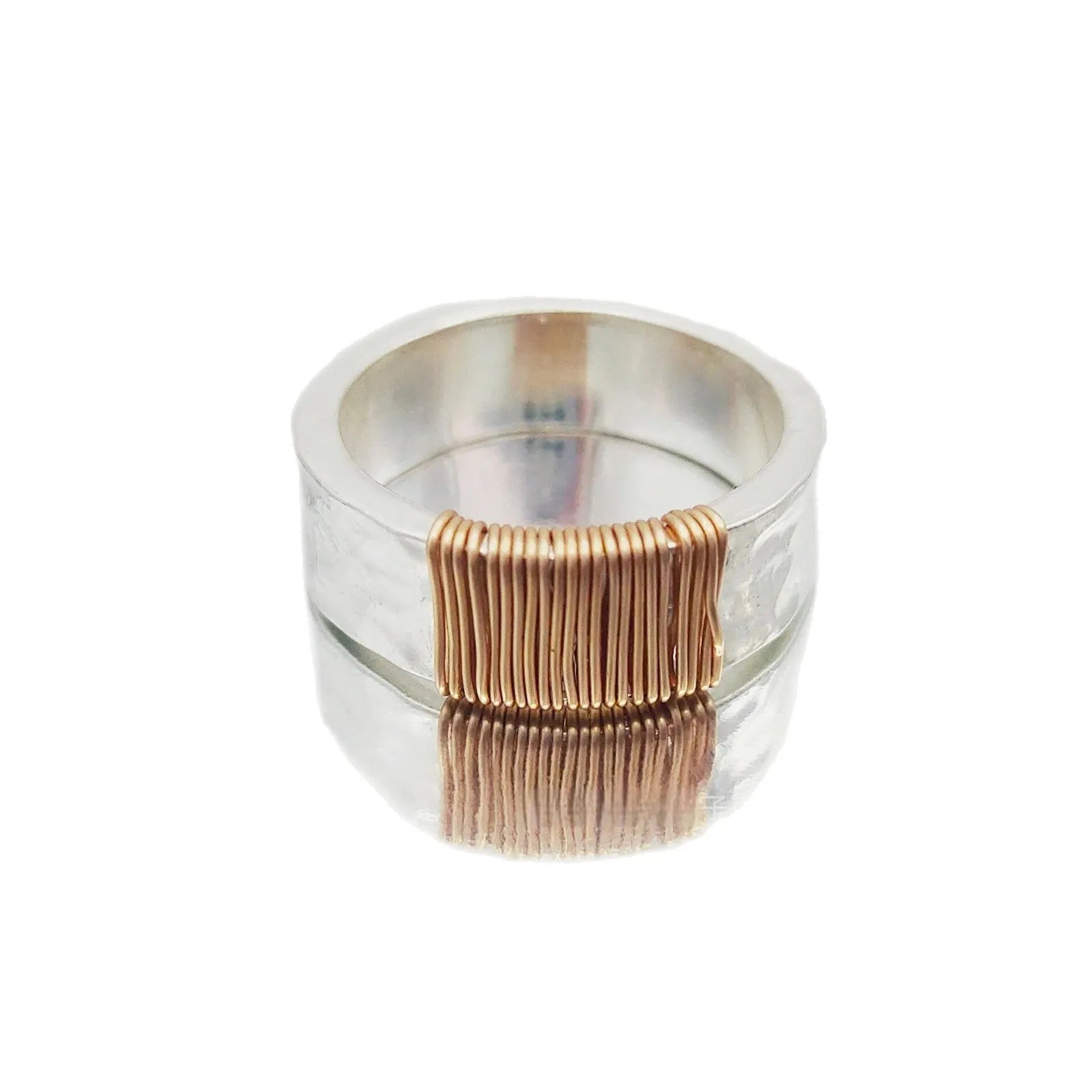 Geometric copper bracelet with irregular coil design and silver-gold electroplated finish.