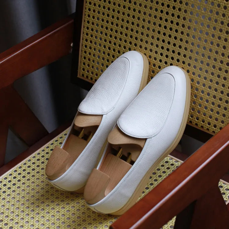 Men's brown handmade leather loafers with a flat TPR sole on a white background.