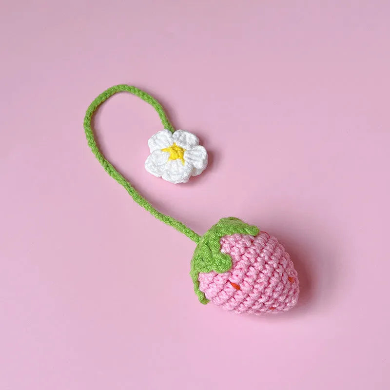 Red wool crochet strawberry pendant with a 35 cm knitted cord against a white background.